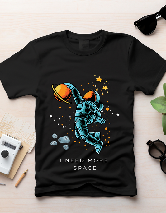 Space by DoodleChic - 100% Organic Cotton Black Printed Kids T-shirt laid flat with space-themed astronaut print, styled with sunglasses and camera.