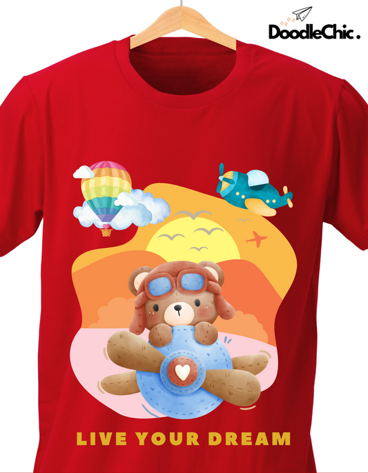 Close-up of Live Your Dream - Doodlechic 100% Organic Cotton Red Kids T-shirt with colorful hot air balloon, airplane, and teddy bear pilot graphic.