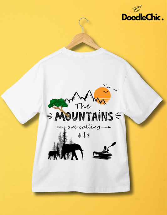 Mountains by DoodleChic-100% Organic Cotton White T-shirt for Kids hanging on yellow wall, featuring nature and adventure-themed graphic.