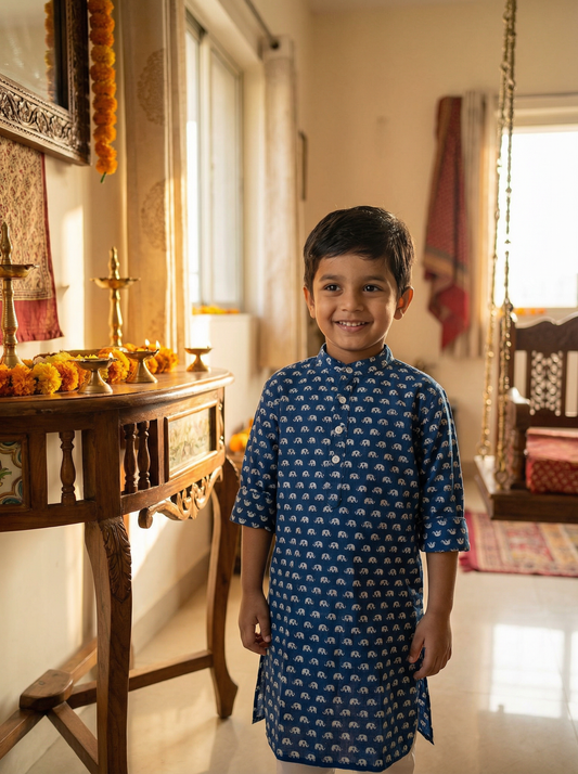 Child in a blue traditional Neel Gaj Kurta outfit standing in a decorated room with religious items.