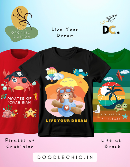DoodleChic Pack of 3 Kids 100% Organic Cotton T-shirts featuring 'Pirates of Crab'bian', 'Live Your Dream', and 'Life at Beach'. Three children's t-shirts with colorful designs and text on a light blue background.