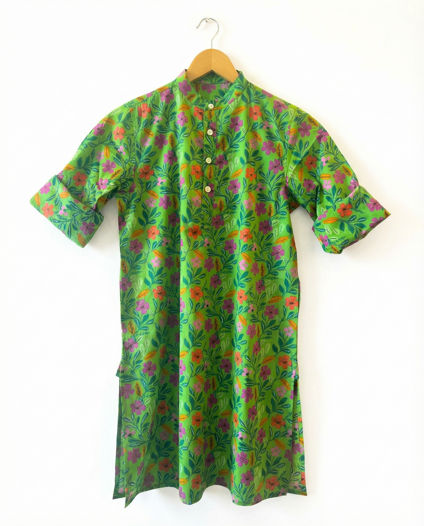 Green floral patterned shirt on a hanger against a white background