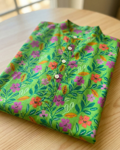 Folded green shirt with floral pattern on a wooden surface